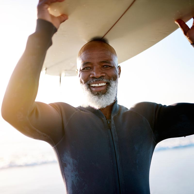 smiling man with surfboard